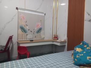 a bedroom with a table and a red chair at Mai homestay in Mỹ Lại (5)