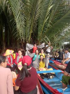 a group of people sitting on rafts under palm trees at Mai homestay in Mỹ Lại (5)