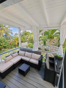 a porch with a couch and chairs on a deck at LaBelleVue Antigua Oceanview Suites and OnSite Car Rentals in Crosbies