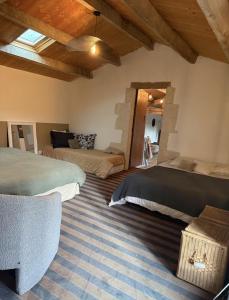 een slaapkamer met 2 bedden in een kamer met houten plafonds bij Le loft in Croix-Chapeau