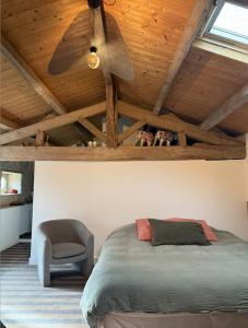 een slaapkamer met een plafondventilator en een bed en een stoel bij Le loft in Croix-Chapeau