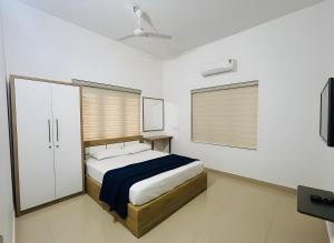 a bedroom with a bed and a flat screen tv at Easy Nest Residency in Kannur +15 photos