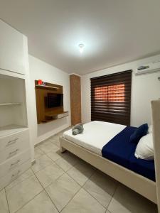 a bedroom with a bed and a television in it at LibiMar in Manta