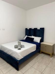 a bed with a blue headboard in a bedroom at LibiMar in Manta