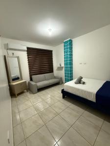 a bedroom with a bed and a couch and a mirror at LibiMar in Manta +6 photos