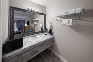 a bathroom with a sink and a large mirror at Days Inn by Wyndham Branson Ozarks in Branson +34 photos