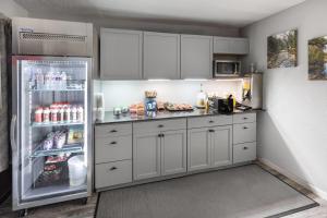 a kitchen with white cabinets and a refrigerator at Days Inn by Wyndham Branson Ozarks in Branson