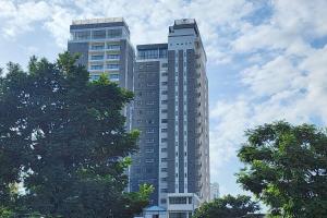 a tall building with trees in front of it at Poulo Wai Hotel, Trademark Collection by Wyndham in Phnom Penh