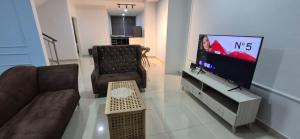 a living room with a couch and a tv at Wonder Villa in Bandar Penawar