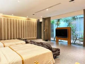 a living room with two beds and a flat screen tv at Moonlight Motel in Taichung