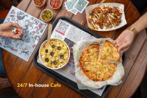 a table with a pizza and other food on it at goSTOPS Coorg in Madikeri