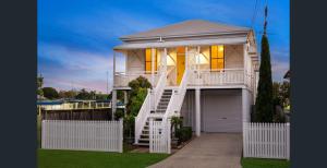 a large white house with a staircase in front of it at Parkside Family Haven - 5bdrm in Brisbane