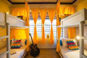 a bedroom with two bunk beds and a guitar at goSTOPS Coorg in Madikeri