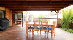 a wooden table and chairs on a patio at Sweet Home at Carrum Downs in Carrum Downs