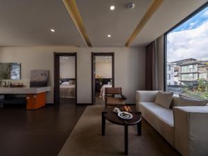 a living room with a couch and a table at Lijiang Ancient City Hitone Rizhao Jinshan Sky Garden Snow Mountain Viewing Resort in Lijiang