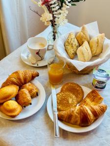 a table with plates of pastries and a cup of coffee at Audotel in Carcassonne