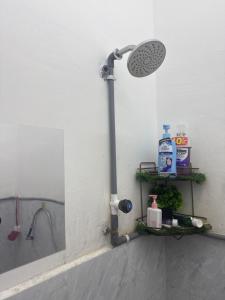 a bathroom with a shower with a sink and a shower at De Bunga Homestay in Parit Raja +8 photos