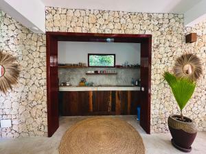 a living room with a stone wall with a table at Beach Front Villa Ocean View Zanzibar in Pongwe