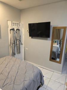 a bedroom with a bed and a flat screen tv on a wall at El Rincón - El Jardín in Tunapuna