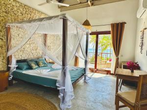 a bedroom with a bed with a canopy at Beach Front Villa Ocean View Zanzibar in Pongwe