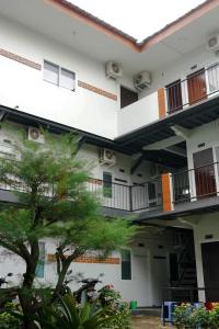 a building with balconies and a tree in the foreground at Puspiptek Residence Syariah in Curug 3 +5 photos