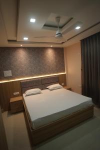 a bedroom with a large bed with white sheets at Aroma Homes in North Lakhimpur +2 photos