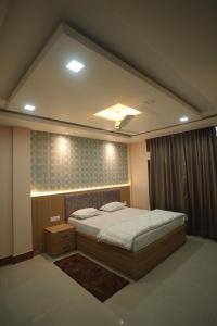a bedroom with a large bed and a mirror at Aroma Homes in North Lakhimpur