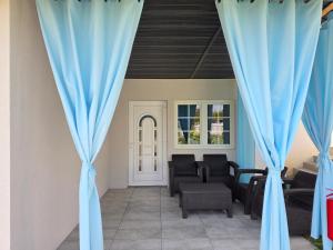 ein Wohnzimmer mit blauen Vorhängen und Stühlen in der Unterkunft Lawendowy dworek in Paszowa