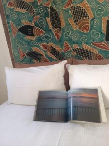 a book sitting on top of a bed with pillows at Chiarù in Naples