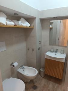 a bathroom with a sink and a toilet and a mirror at Chiarù in Naples