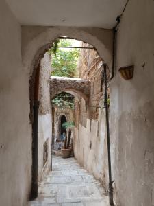 an alley with an archway in an old building at Chiarù in Naples