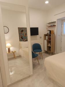 a bedroom with a mirror and a bed and a chair at Chiarù in Naples