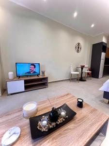 een woonkamer met een tv en een tafel bij Apartment Voulas 3 in Ptolemaida