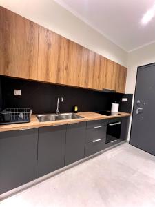 een keuken met een spoelbak en houten kasten bij Apartment Voulas 3 in Ptolemaida