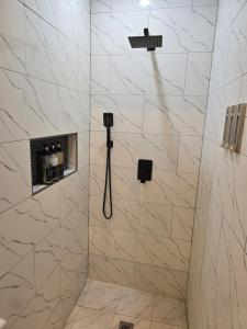 a bathroom with a shower with marble tiles at El Rincón - El Jardín in Tunapuna +4 photos