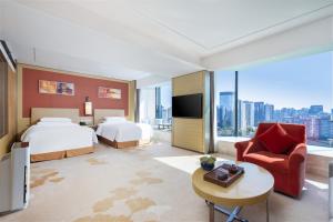 a hotel room with a bed and a couch and a tv at Grand Metropark Hotel Beijing in Beijing