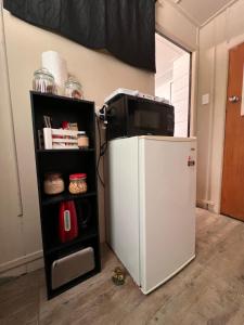 a small refrigerator with a microwave on top of it at Cosy rural getaway in Otorohanga