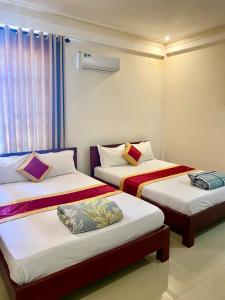 a room with two beds in a room at Motel Rose in Hue