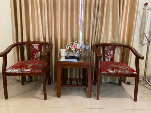 two chairs and a table with a vase of flowers at Motel Rose in Hue