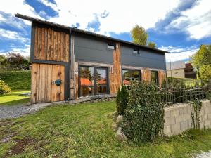 Banský StudenecにあるIRON LODGE Banský Studenecの木製のドアと窓を備えた納屋風の家