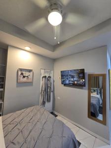 a bedroom with a bed and a flat screen tv at El Rincón - El Jardín in Tunapuna