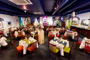 um restaurante com mesas e cadeiras num quarto em Cape Town Lodge Hotel em Cidade do Cabo