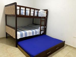 Dos literas en una habitación con un colchón azul. en Refugio del Mar, en Manta