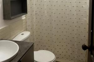 un baño con inodoro y lavabo en Refugio del Mar, en Manta