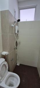 a bathroom with a toilet and a window at Wonder Villa in Bandar Penawar