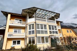 uma grande casa amarela com uma varanda em Relax in Thaur em Thaur