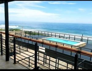 a balcony with a swimming pool and the ocean at Blue horizon in La Mercy