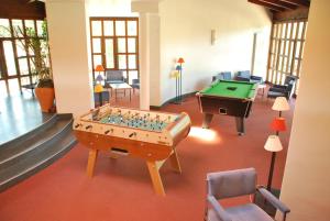 um quarto com uma mesa de matraquilhos e uma mesa de bilhar em ULVF Hôtel Castel Luberon em Apt