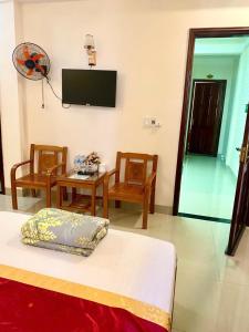 a room with a bed and a table and a flat screen tv at Motel Rose in Hue +25 photos