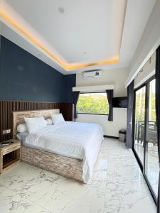 ラブハン・バジョにあるHostel Labuan ORAの青い壁の大きなベッドのある寝室